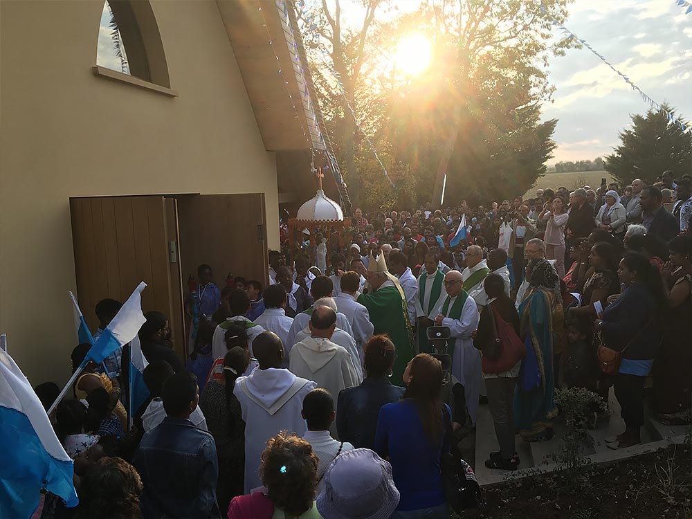 La procession arrive devant la chapelle de Notre-Dame de France dans la lumière du soleil couchant