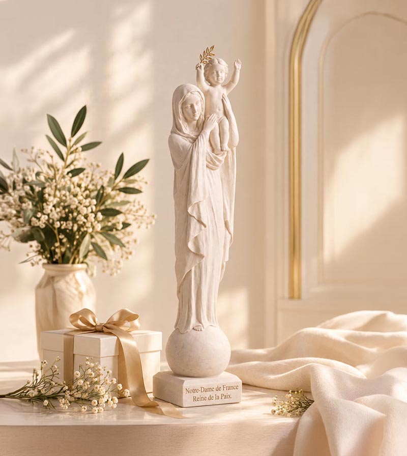 La statue de Notre-Dame de France dans un salon lumineux, à côté d'un bouquet et d'un cadeau