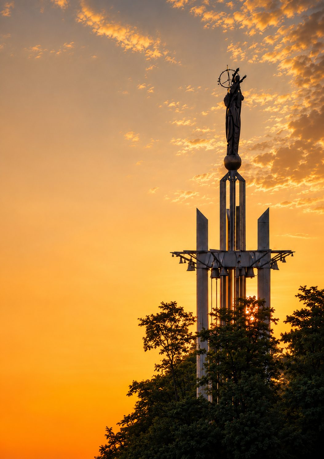 La statue de Notre-Dame de France au sommet du carillon de Baillet-en-France, au coucher du soleil