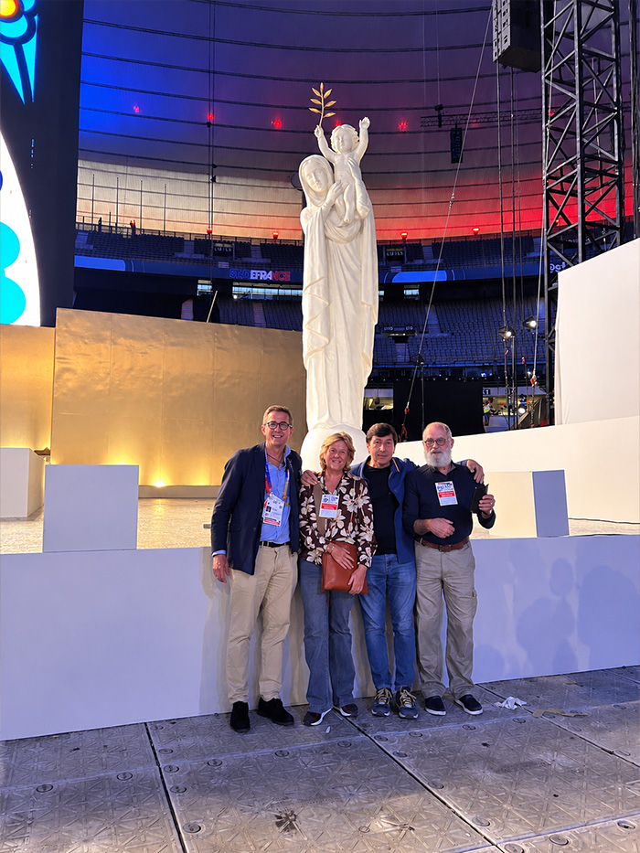 Des membres de la Confrérie Notre-Dame de France au pied de la statue de 4 mètres au Stade de France