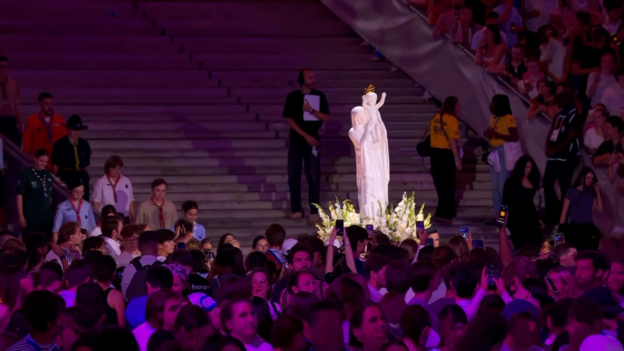 Des scouts accompagnent la Vierge pèlerine de Notre-Dame de France au pied des gradins du Stade de France