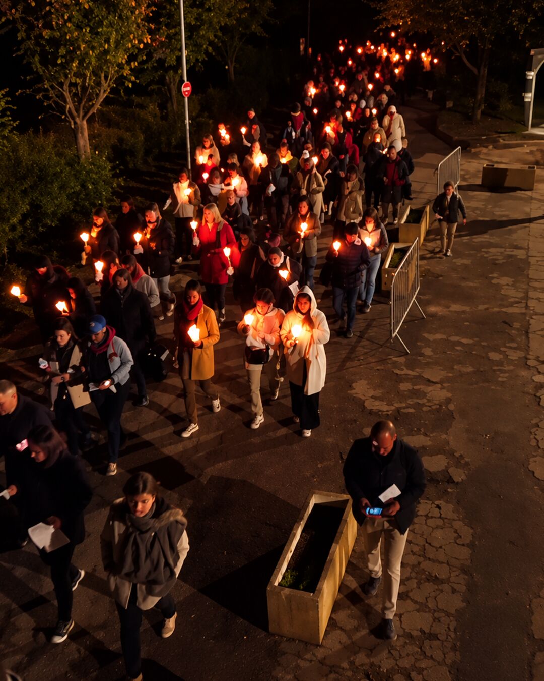 Un long cortège de bougies dans les allées du sanctuaire.