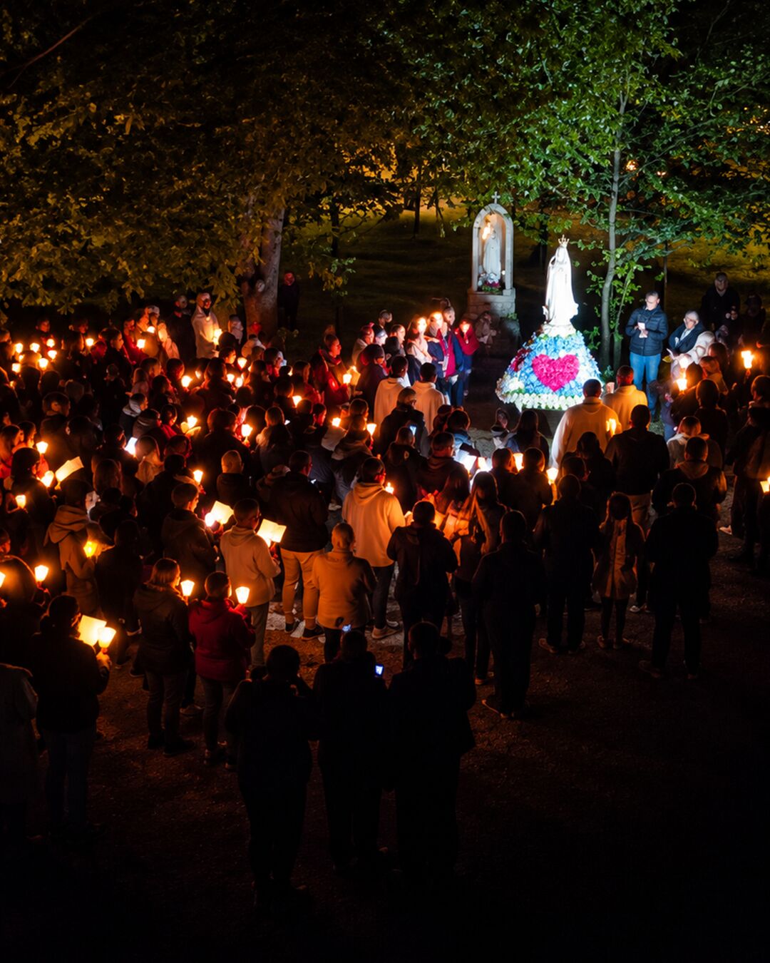 Devant l’oratoire, la prière se prolonge.