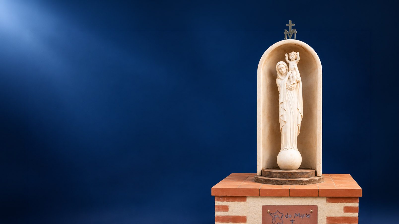Un oratoire du M de Marie : la statue de Notre-Dame de France dans sa niche, sur un socle de brique portant la plaque du M de Marie