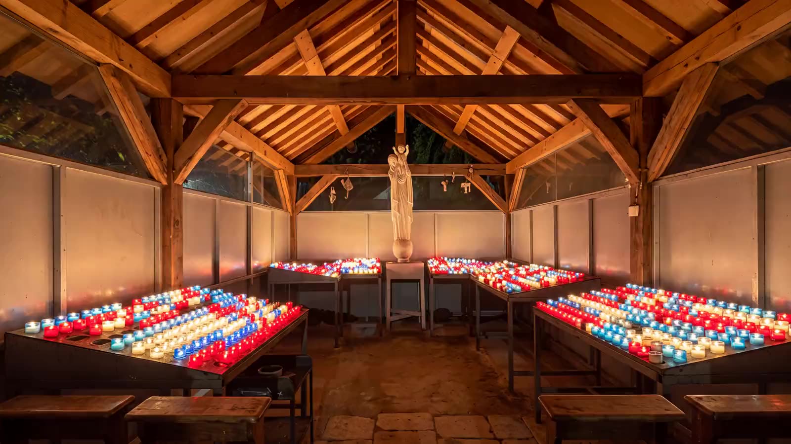 L'oratoire de Notre-Dame de France, sa charpente de bois et ses cierges bleus, blancs et rouges